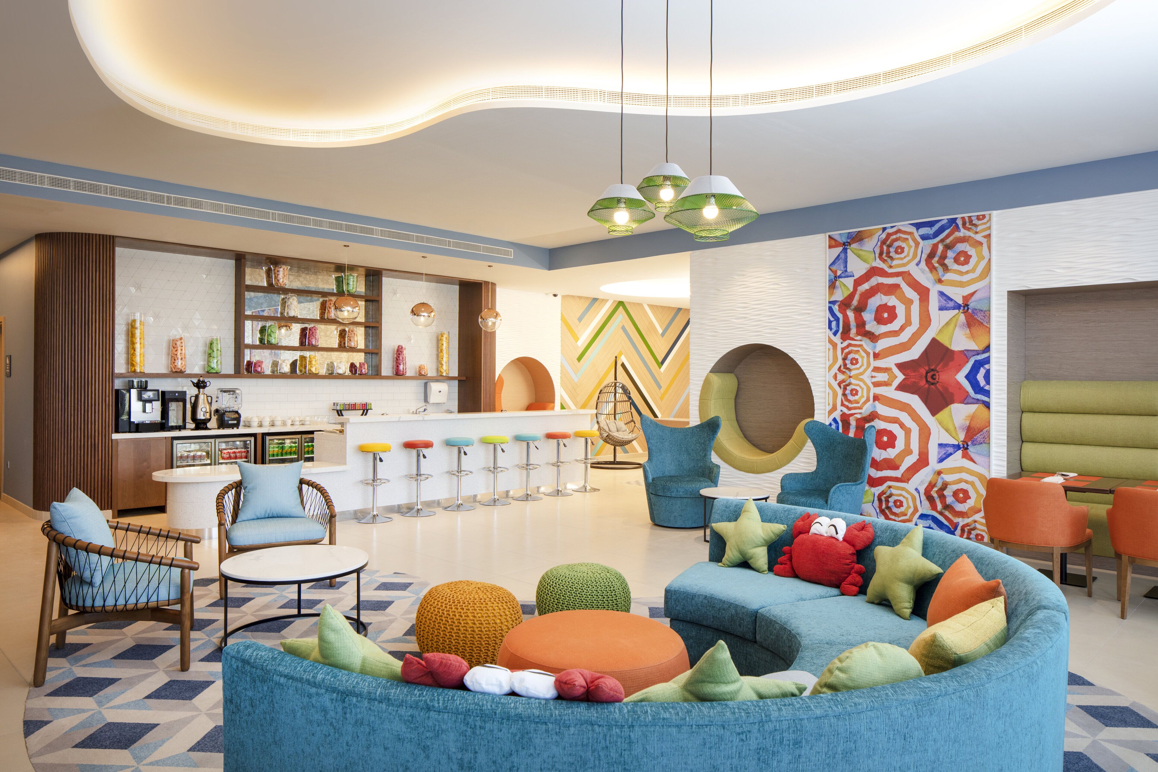 A modern interior with a bar area, seating, and colorful decor.