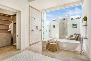 Une salle de bain moderne avec une baignoire sur pieds, une douche à l’italienne et un grand miroir.