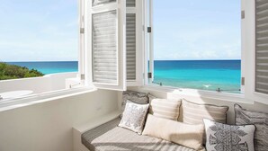 A balcony with a view of the ocean, a white wall, and a window with white shutters. - Sand Villa – Greek-Inspired Elegance on the Shores of Long Bay, Anguilla (Long Bay Village)