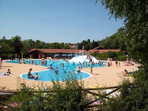 A public swimming pool with multiple lanes, surrounded by a sandy beach area and shaded by trees. - Charming farmhouse with terrace and pets allowed (Saint-Marcel-d'Urfé)