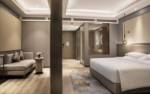 A modern hotel room with a bed, a sofa, a small table with a vase, and a large mirror. - Crowne Plaza Changsha Development Zone by IHG (Changsha)