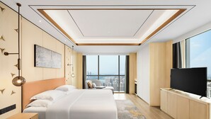 A modern hotel room with a large bed, a TV, a city view, and a minimalist design. - Crowne Plaza Changsha Development Zone by IHG (Changsha)