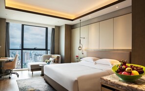 A modern hotel room with a large bed, a desk, and a view of the city. - Crowne Plaza Changsha Development Zone by IHG (Changsha)