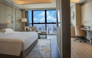 A modern hotel room with a large bed, a desk, and a view of the city. - Crowne Plaza Changsha Development Zone by IHG (Changsha)
