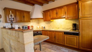 A kitchen with wooden cabinets, a stone countertop, and a built-in oven.