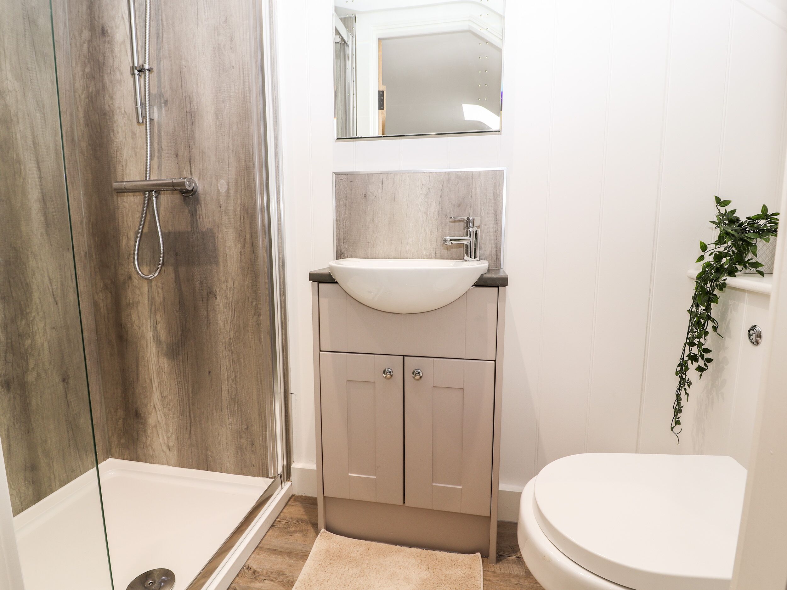Une salle de bain avec une douche, un lavabo et des toilettes.