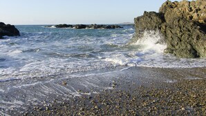 A rocky coastline with waves crashing against the shore. - Sgubor (Holyhead)
