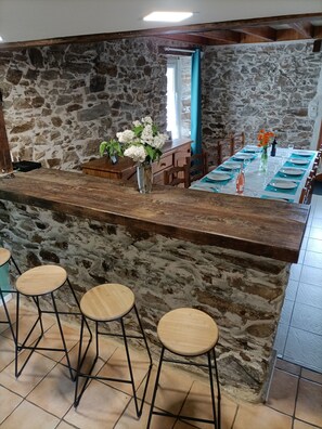 Eine Bar mit steinverkleideter Wand, einer Holztresore und einem Tisch, gedeckt zum Essen.