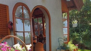 A rustic wooden bench with a wicker basket of flowers and a potted plant.