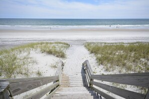 A wooden boardwalk leading to a sandy beach with the ocean in the background. - Experience ocean views in this 3-bedroom Beachside Bungalow in North Topsail Beach. (North Topsail Beach)