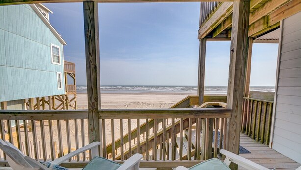 A wooden deck with two lounge chairs and a view of the beach. - Oceanfront bliss awaits you at Cool Story, a 3BR retreat in North Topsail Beach. (North Topsail Beach)