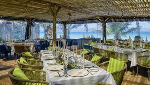 An outdoor dining area with tables set for a meal, overlooking a body of water.