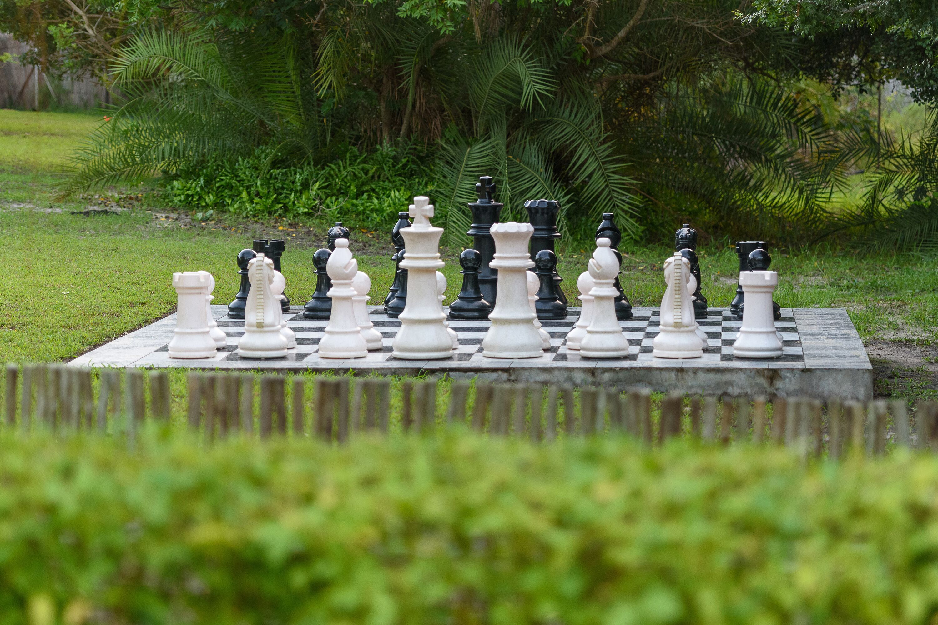 Un jeu d’échecs installé à l’extérieur, les pièces étant disposées pour une partie.