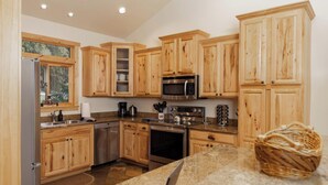 A kitchen with wooden cabinets, stainless steel appliances, and a granite countertop.