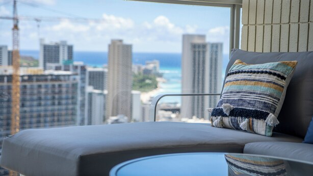 A balcony with a view of a cityscape and the ocean.