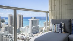 A balcony with a city view, a cushioned seating area, and a tiled wall.