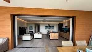 A modern open-plan living area with a kitchen, dining space, and seating area. - Beachfront, sea view 3 BDR luxury The Shore @ Blue Bay Beach and Golf Resort (Willemstad)
