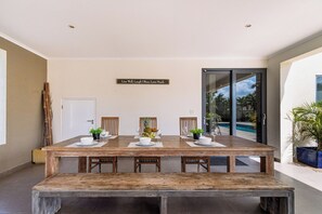 A dining area with a wooden table set for four, chairs, and a wall-mounted sign.