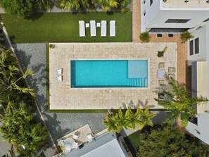 An aerial view of a swimming pool with sun loungers and a small deck area. - Villa Haven: 6BR w/ Private Pool Near Palm Beach! (Noord)