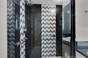 Chuveiro, toalhas de banho, shampoo, papel higiênico