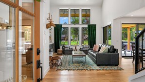 A spacious living room with a large window, a fireplace, and a cozy seating area.