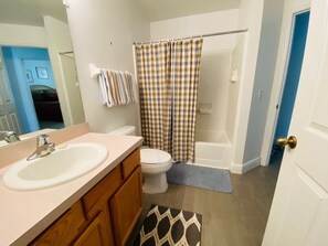 A bathroom with a sink, toilet, and shower curtain.
