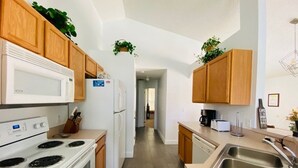 Una cocina moderna con armarios de madera, una estufa blanca, un refrigerador y un lavamanos.