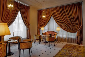 A hotel room with a round table, two armchairs, a sofa, and a patterned rug. - Hôtel Madame Rêve (Paris)