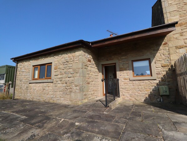 A stone building with a small entrance, a window, and a chimney. - The Proven House (Preston)