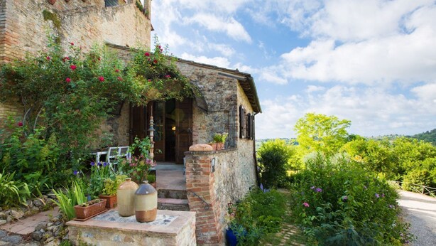 A rustic stone building with a wooden door and steps leading to a garden. - Le Rose di Montagnana (San Gimignano)