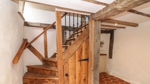 Una escalera de madera con barandilla de metal y una puerta de madera.