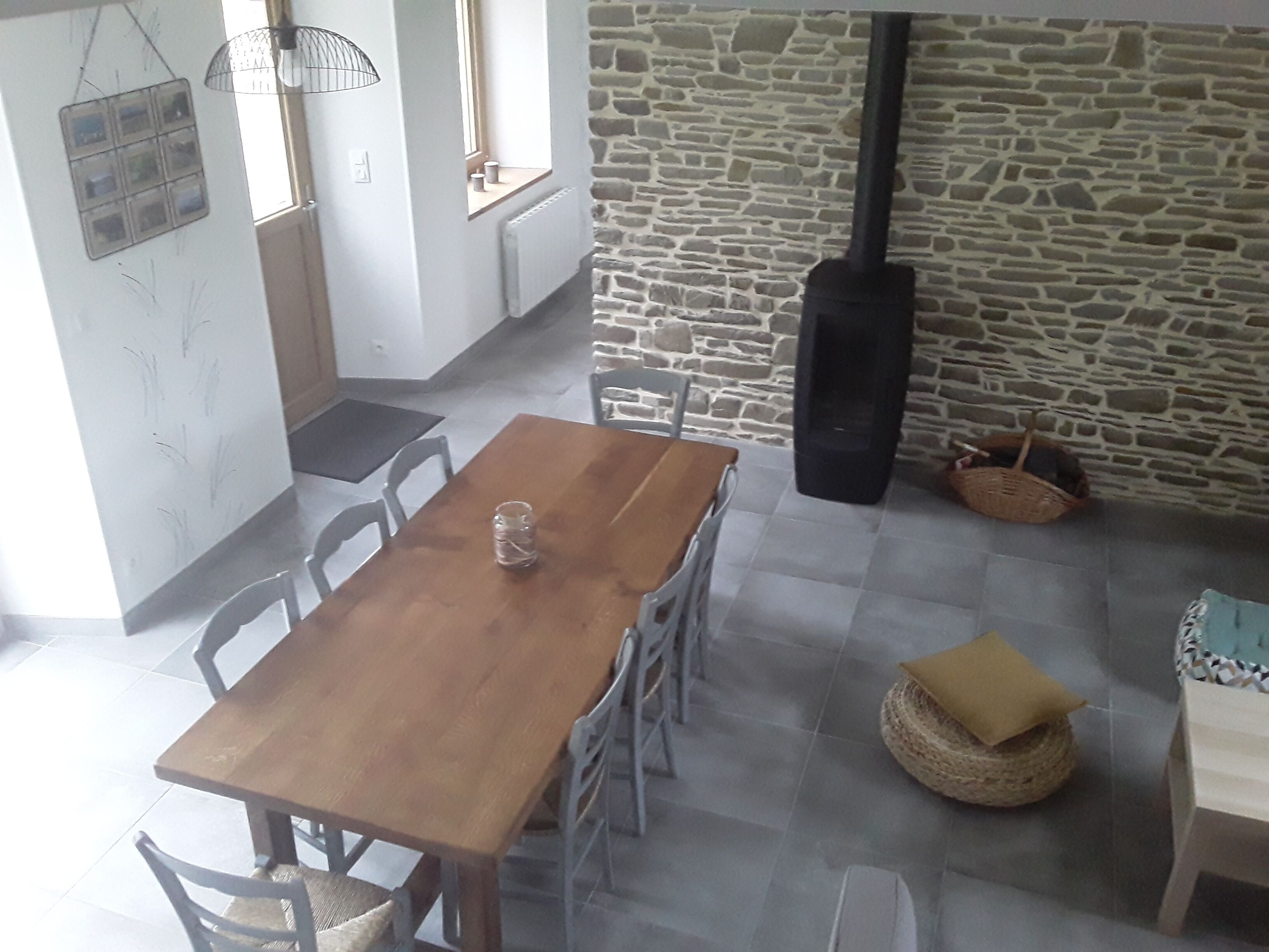 Un'area pranzo con tavolo e sedie in legno, un muro in pietra e un caminetto.