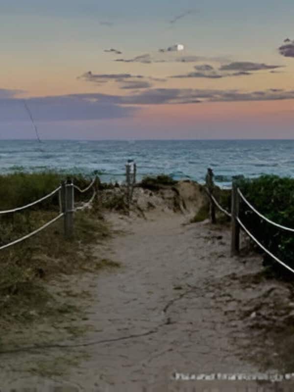 Na praia, areia branca, guarda-sóis, toalhas de praia