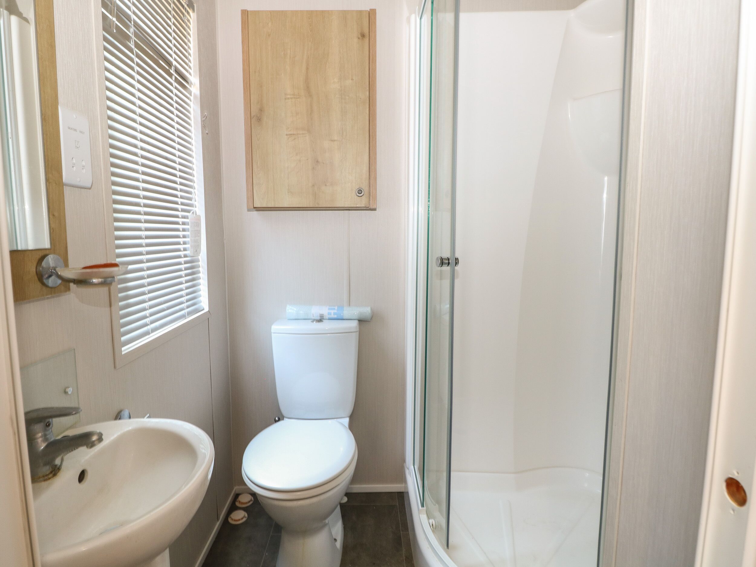 A bathroom with a toilet, sink, and shower.