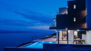 A modern multi-story building with a pool, outdoor seating, and a view of the sea. - Seaview Villa Marila with a private heated pool with hydromassage, 3 en-suite bedrooms (6+2 people), 1km from the beach (Lokva Rogoznica ( Omis))