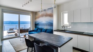 A modern kitchen with a large island, a dining area with chairs, and a view of the sea through large windows. - Seaview Villa Marila with a private heated pool with hydromassage, 3 en-suite bedrooms (6+2 people), 1km from the beach (Lokva Rogoznica ( Omis))