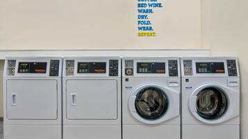 A row of four white washing machines with digital displays, arranged side by side.
