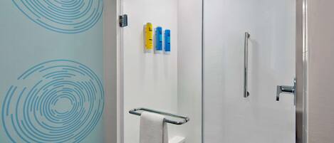 A modern bathroom with a glass shower enclosure, a white toilet, and a towel rack.