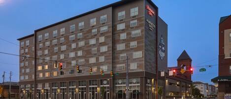 Un hôtel moderne à plusieurs étages, doté de grandes fenêtres et d’une enseigne bien visible indiquant qu’il s’agit d’un Hampton Inn.
