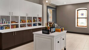 Una cocina con armarios blancos, un mini bar y un letrero que dice "Hilton Honors".