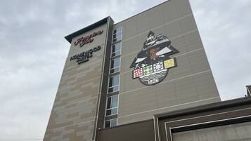 A hotel sign with the name "Homewood Suites by Hilton" and a logo featuring a woman in a hat.