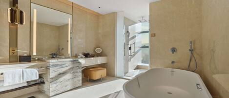 A modern bathroom with a large freestanding bathtub, a vanity with a mirror, and a shower area.
