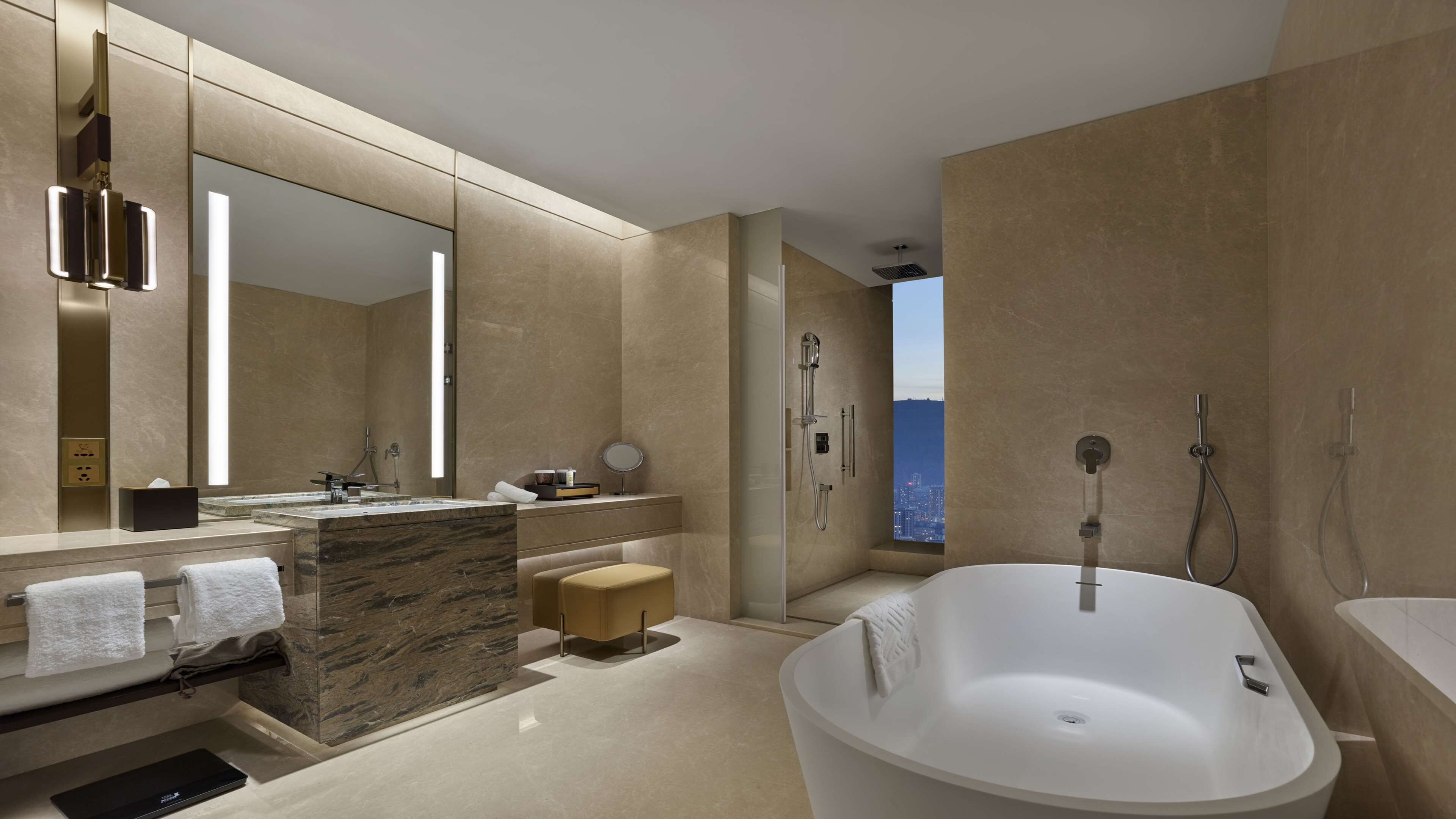 A modern bathroom with a large bathtub, a vanity with a mirror, and a shower area.