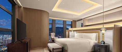 A modern bedroom with a large bed, a desk, and a view of a cityscape.