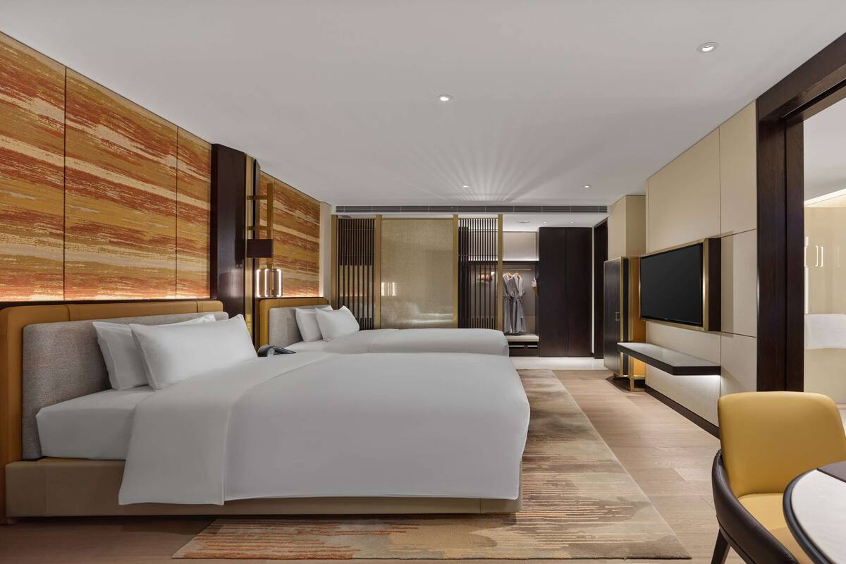 Une chambre d’hôtel moderne équipée d’un grand lit, d’une télévision, d’un bureau et d’une salle de bain.