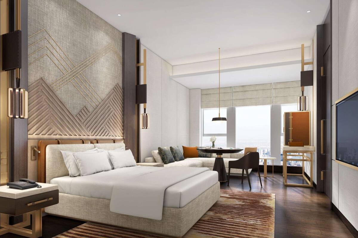 Une chambre d’hôtel moderne, dotée d’un grand lit, d’un bureau et d’une télévision.