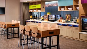 A modern breakfast area with a counter, seating, and various food items. - Home2 Suites By Hilton Tupelo, Ms (Tupelo)