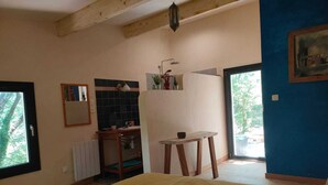 Un dormitorio con cama, una mesita, un espejo, un lavamanos y una ventana.