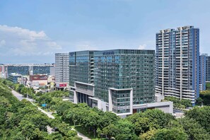 Located in a vibrant urban setting, this high-rise building offers stunning views of lush greenery and modern architecture.