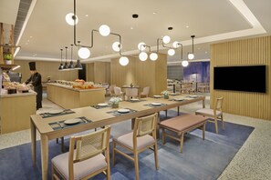 Enjoy meals in a spacious dining area with a long table and comfortable seating for guests.